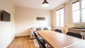 Eine moderne Küche mit einem Holztisch und Stühlen, einem eingebauten Backofen und einem Fenster mit Jalousien.