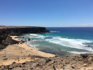 Eine Küstenlandschaft mit Strand, felsigem Gelände und dem Ozean.