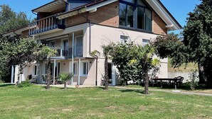 A modern two-story house with a balcony, large windows, and a well-maintained lawn. - Weinberg Idyll vacation apartment - Fantastic view over vineyards to Lake Constance (Lindau)