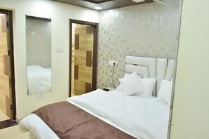 A hotel room with a bed, a mirror, and a door. - Rudhraksh Villa 4BR Perfect vacay Villa (Mussoorie)
