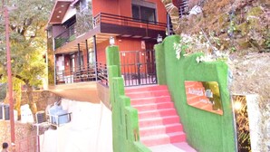Un bâtiment à deux étages, à la façade rouge, doté d’un balcon à l’étage supérieur et d’une enseigne indiquant « Ruhrkraksh Villa ».