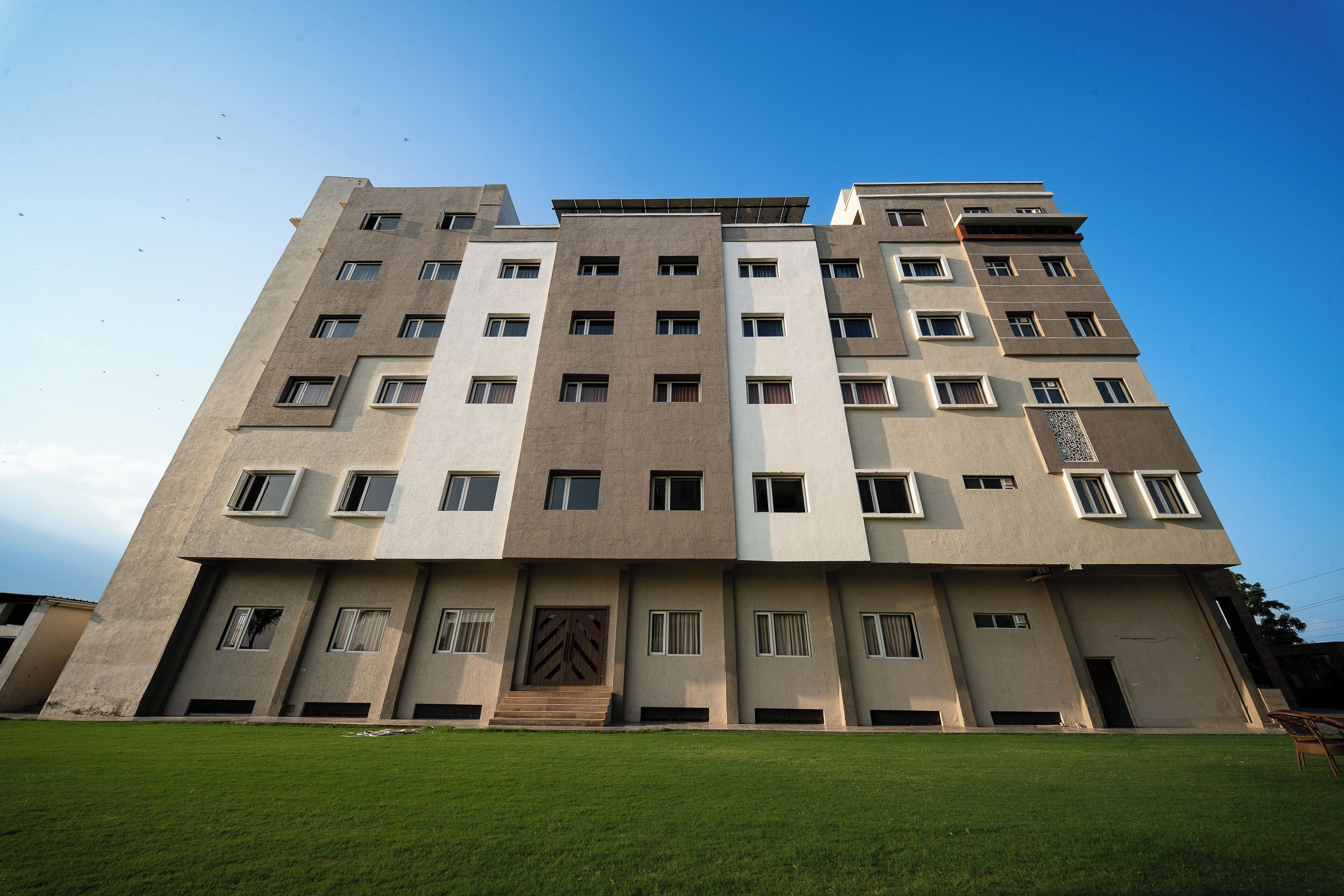 Un edificio de varios pisos con fachada simétrica, numerosas ventanas y una entrada central.