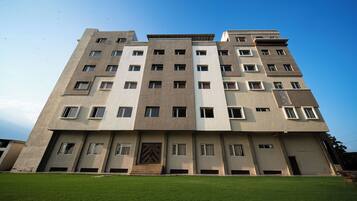 Un edificio de varios pisos con fachada simétrica, numerosas ventanas y una entrada central.