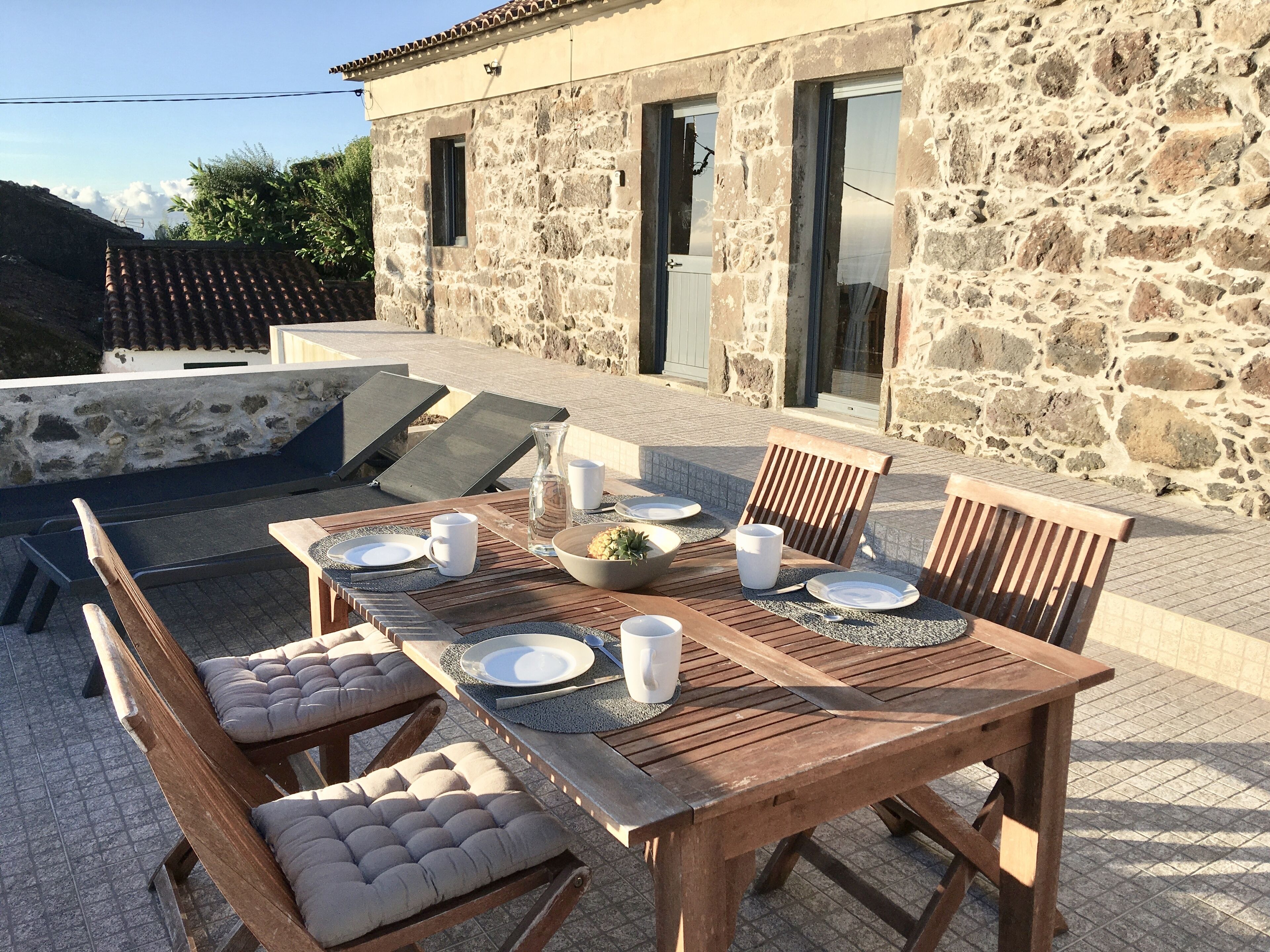 An outdoor dining area with a stone building in the background.
