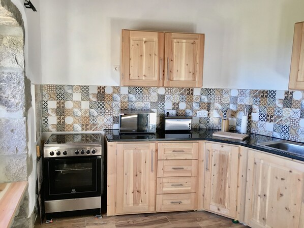 A kitchen with wooden cabinets, a stove, a microwave, and a toaster.