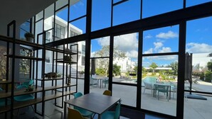 A modern indoor space with large windows overlooking a pool area. - Cozy loft with private jacuzzi. (Mérida)