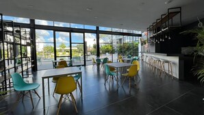 A spacious indoor area with large windows, multiple tables and chairs, and a bar area. - Cozy loft with private jacuzzi. (Mérida)