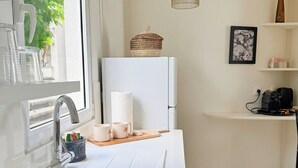 A modern kitchen with a white sink, stainless steel faucet, and a hanging light fixture. - Cosy (Apt7) - Patio, Sea View and pool (indigo Bay)