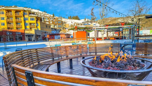 A public square with a circular wooden bench area and a central fire pit. - Canyons View 06: 2 Bed 2 bath walk to the lift (Park City)