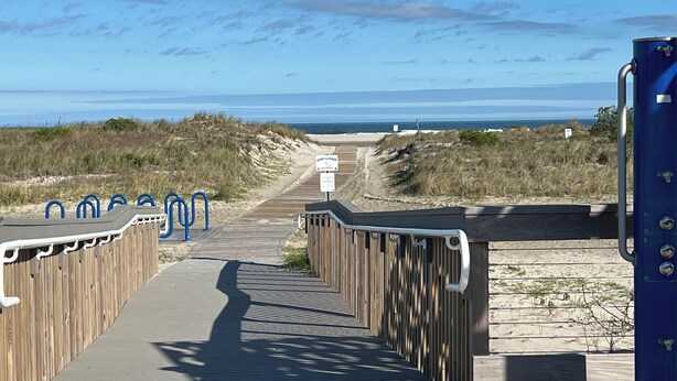 A wooden boardwalk leading to a beach with a clear view of the ocean. - The Townhouse Cozy Ocean-front first floor condominium. (Wildwood Crest)