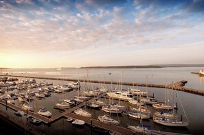 Een jachthaven met vele boten afgemeerd aan houten steigers.