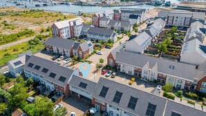 An aerial view of a residential area with modern houses, a marina, and a bridge in the background. - Seas the Day - Moments from Hamworthy Beach (Poole)