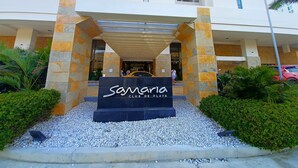 La entrada al Samaria Club de Playa, con un arco de piedra, un cartel y un camino de grava.