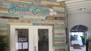 A beach-themed cafe with a wooden facade and an 'OPEN' sign.