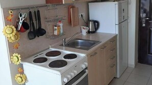 Une cuisine de taille réduite équipée d’une cuisinière, d’un four, d’un évier et d’un réfrigérateur.