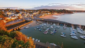 Une ville côtière dotée d’un port de plaisance rempli de bateaux, d’une plage de sable et d’immeubles résidentiels.