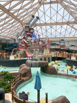 Et vandland indendørs med en stor swimmingpool, vandrutsjebaner og forskellige legeområder.