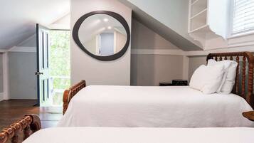 Una camera da letto con un letto grande, uno specchio rotondo e un soffitto spiovente.