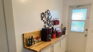 Una cucina con piano di lavoro in legno, una macchina da caffè e diversi utensili da cucina.