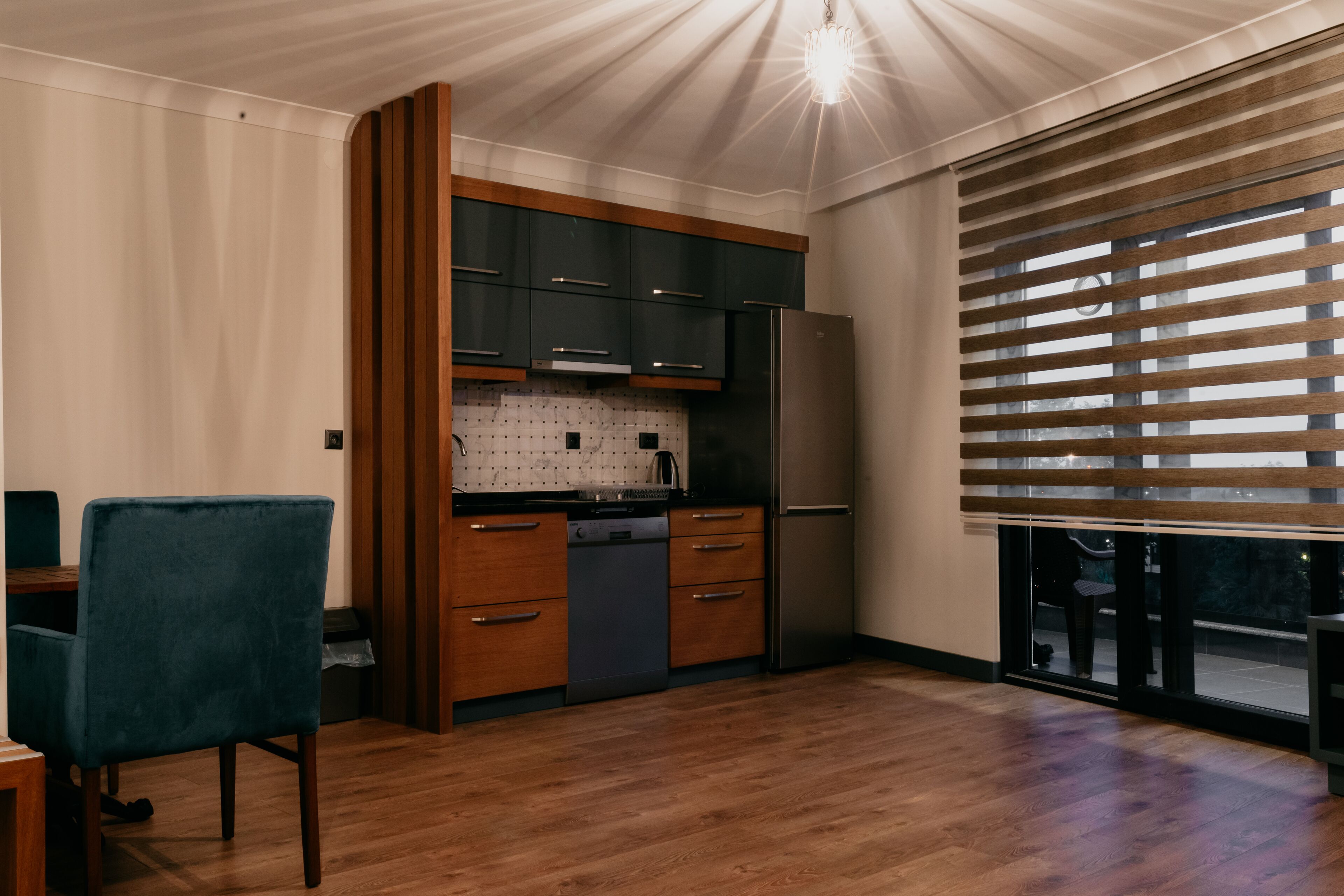 Una cocina moderna con armarios oscuros, un refrigerador de acero inoxidable y una encimera de madera.