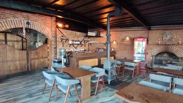 Un ristorante rustico con pareti in mattoni, arredi in legno e un camino in muratura.