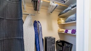 A neatly organized closet with hanging clothes, folded towels, and a laundry basket. - ✨ #3 Studio close to Bike Rental and Beach (Fort Lauderdale)