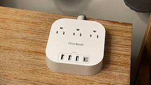 Een OneBeat ISmart stekkerdoos met meerdere USB-poorten en een 4,5A USB-uitgang, geplaatst op een houten oppervlak.