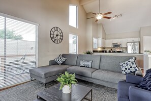 A modern living room with a grey sectional sofa, a coffee table with a plant, and a ceiling fan. - BEAUTIFUL RESORT LAKEHOUSE! (Montgomery)