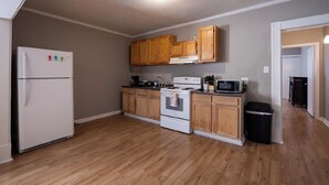 A kitchen with wooden cabinets, a white refrigerator, a stove, and a microwave. - Downtown sulphur getaway (Sulphur)