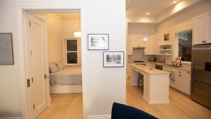 Una cucina moderna con mobili bianchi, un'isola centrale e forno integrato.