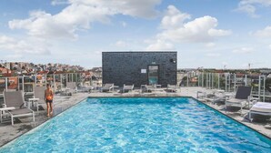 Une piscine sur le toit offrant une vue dégagée sur le paysage urbain en arrière-plan.