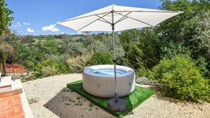 An outdoor hot tub with a canopy, surrounded by greenery and a gravel path. - Lovely home in Toffia (Toffia)