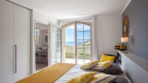 Un dormitorio con cama, vistas al mar y un balcón.