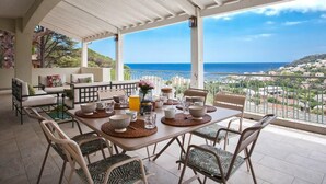 Comedor con una mesa dispuesta para cuatro, con vista al mar.