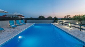 A swimming pool with blue tiles, two blue lounge chairs, and a fence. - Awesome apartment in Gornje Rastane (Gornje Rastane)