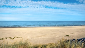 Ein Strand mit blauem Himmel und ruhiger See.