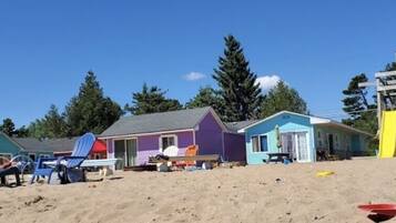 A beachside property with colorful houses, a sandy beach, and a playground.