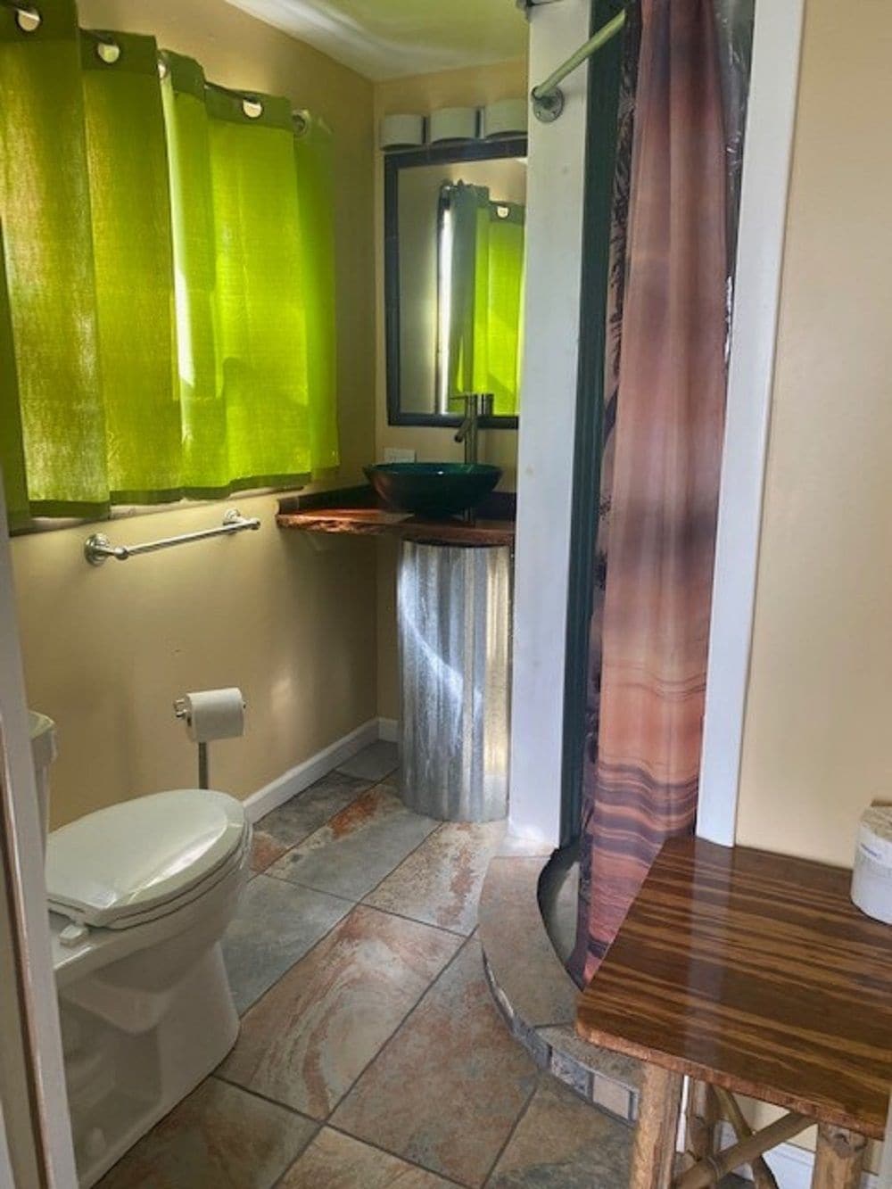 Ein Badezimmer mit Toilette, Waschbecken und einem Spiegel darüber sowie einer Duschkabine.