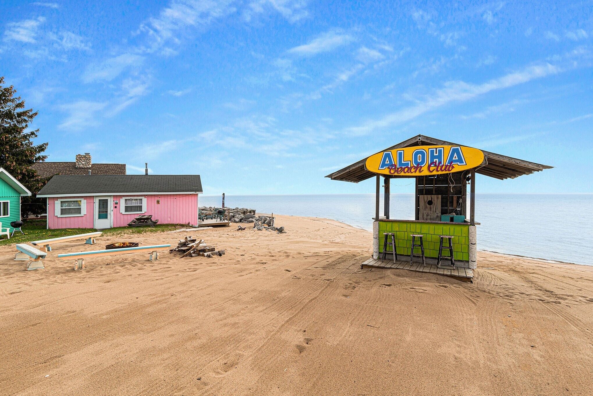 A beachside location with a pink building and a beach club named 'ALOHA Beach Club'.