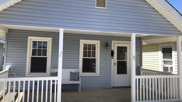 A two-story house with a porch, white railings, and a mailbox. - Hop, skip, jump to the beach! (Point Pleasant Beach)