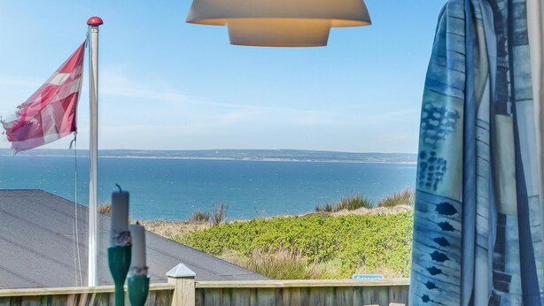 A view of the sea from a balcony with a flag, a lamp, and a sign reading "Cottage". - Stunning home in Struer with WiFi (Struer)