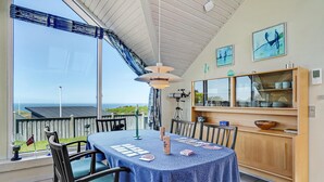 A dining area with a table set for four, a telescope, and a view of the sea. - Stunning home in Struer with WiFi (Struer)