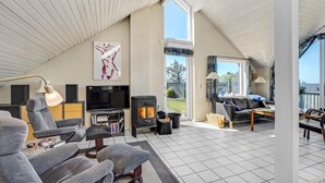 A spacious living area with a high ceiling, a fireplace, a television, and a comfortable seating arrangement. - Stunning home in Struer with WiFi (Struer)