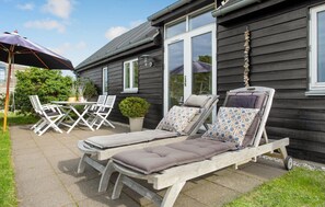 Relax in this serene outdoor seating area with lounge chairs, a small table, and potted plant.