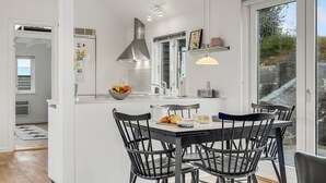 A modern kitchen with a central island, black chairs, and a dining table.