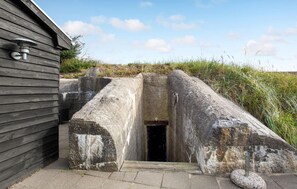 Step into history through this ancient stone entrance, flanked by imposing stone walls and a sturdy metal door.