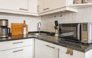 Een koelkast, een oven, een kookplaat, een koffiezetapparaat/waterkoker