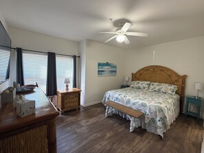A bedroom with a bed, a desk, a chair, a nightstand, a ceiling fan, and a window with blinds. - Gulf Shores Getaway w/Large Pool   – 1 Mile to the Beach! (Gulf Shores)