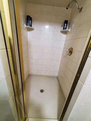 Een bad/douchecombinatie, handdoeken, zeep, shampoo