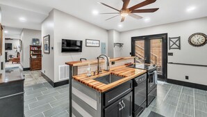 Una cucina moderna con isola centrale, elettrodomestici in acciaio inossidabile e ventilatore a soffitto.